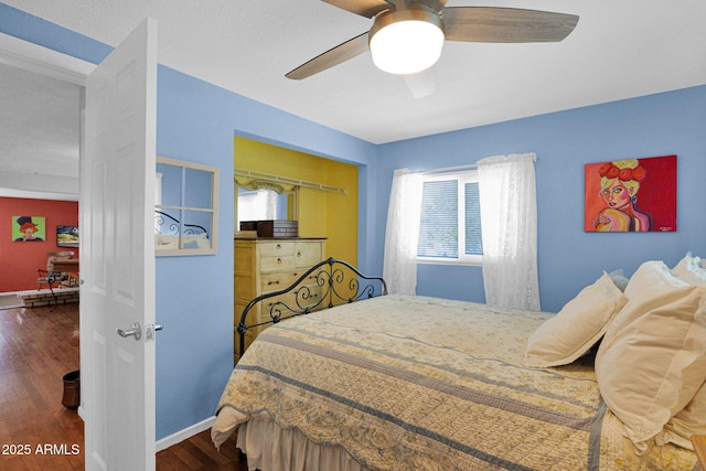 bedroom with a ceiling fan, baseboards, and wood finished floors