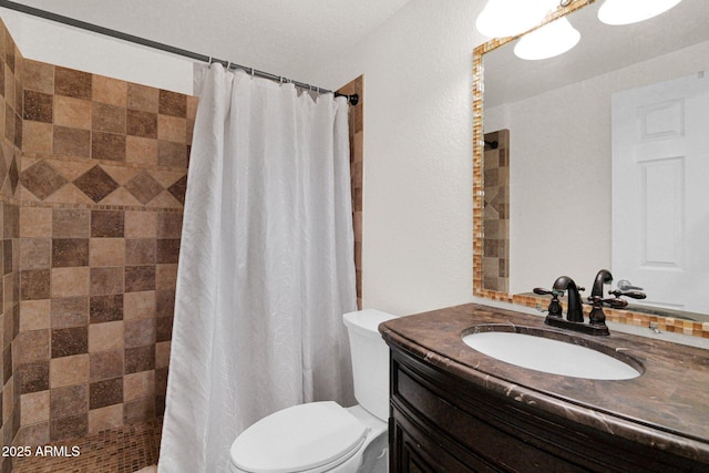 bathroom with vanity, toilet, and tiled shower