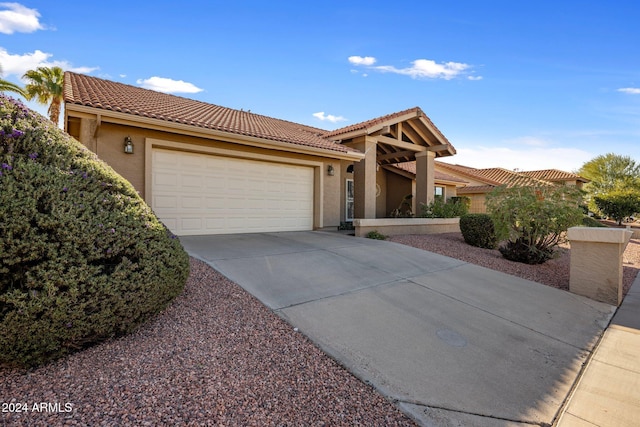 1017 E Grandview Rd, Phoenix, AZ 85022 - view of front of house featuring an attached garage, a tiled roof, concrete driveway, and stucco siding