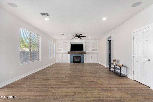 unfurnished living room featuring ceiling fan and dark hardwood / wood-style floors