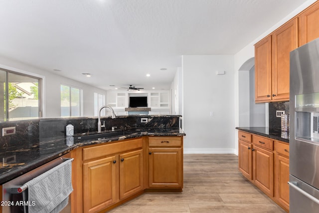 kitchen with light hardwood / wood-style floors, sink, and dark stone counters