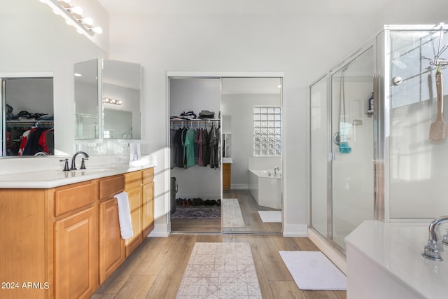 bathroom featuring vanity, wood-type flooring, and shower with separate bathtub