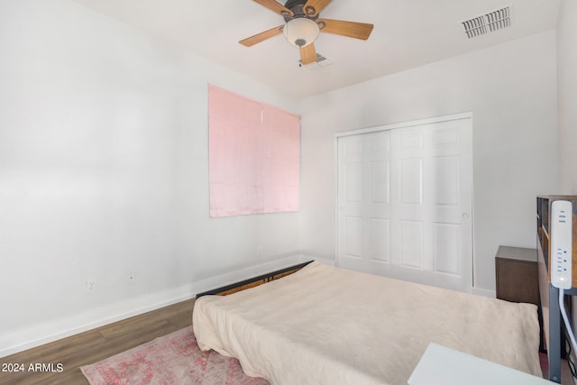 bedroom featuring dark wood-type flooring, ceiling fan, and a closet