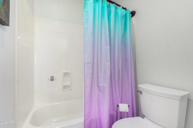 bathroom with toilet and shower / bath combo with shower curtain