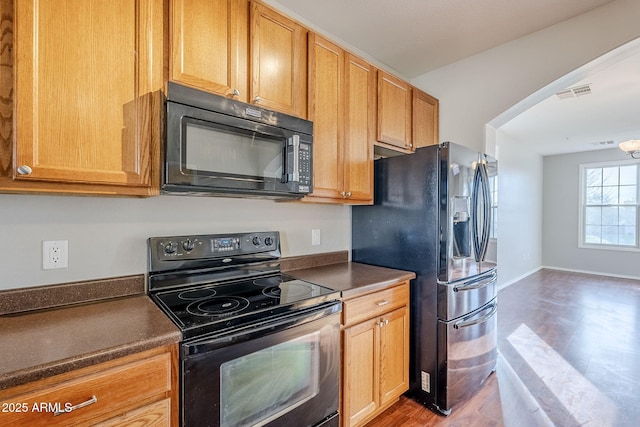 kitchen with hardwood / wood-style flooring and black appliances