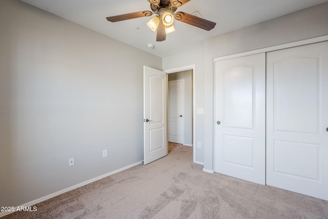 unfurnished bedroom with ceiling fan, a closet, and light carpet