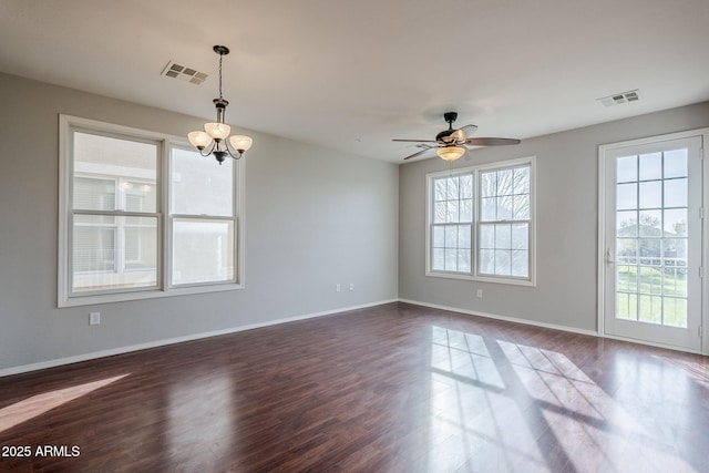 spare room featuring dark hardwood / wood-style flooring and ceiling fan with notable chandelier