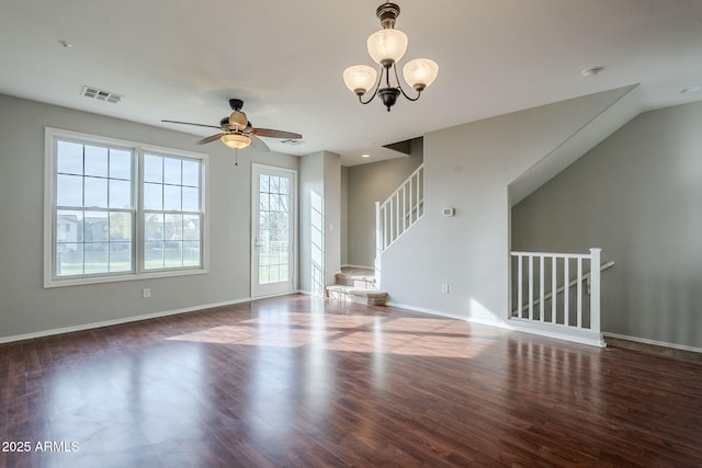 unfurnished living room with ceiling fan with notable chandelier and dark hardwood / wood-style floors