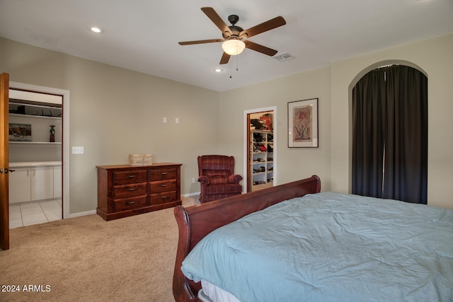 carpeted bedroom featuring ceiling fan, a closet, and a spacious closet