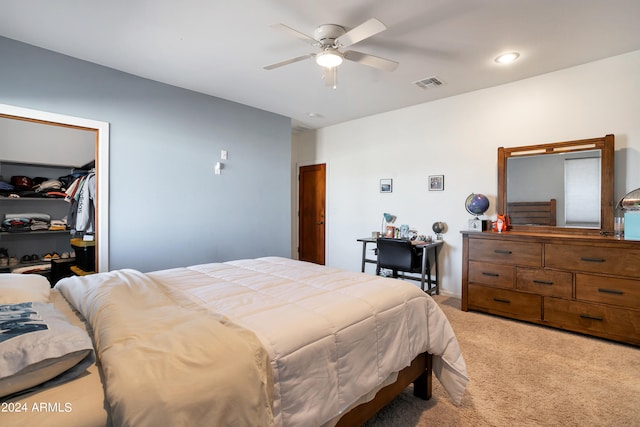 carpeted bedroom with a closet, a walk in closet, and ceiling fan