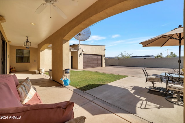 view of patio / terrace with ceiling fan and a garage