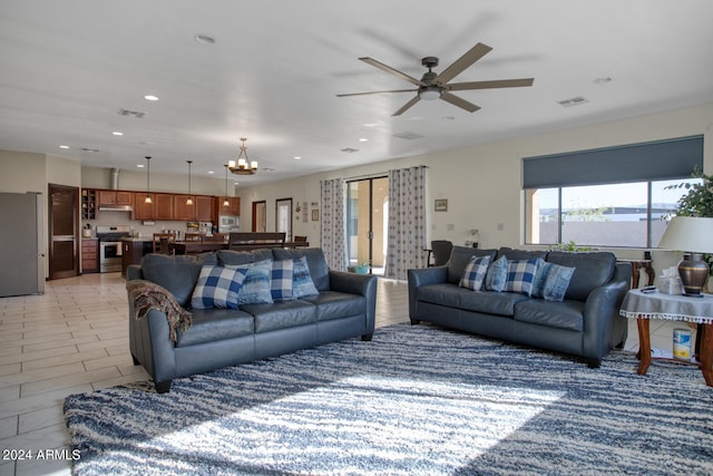 living room with ceiling fan with notable chandelier