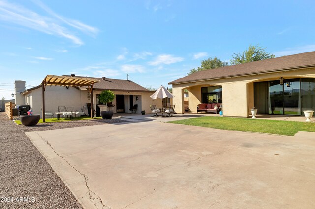 rear view of house featuring a pergola and a patio area