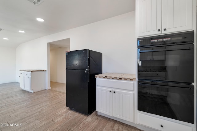 kitchen featuring white cabinetry, light hardwood / wood-style floors, and black appliances