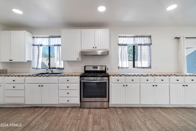 kitchen featuring a healthy amount of sunlight, stainless steel gas stove, sink, and light hardwood / wood-style flooring