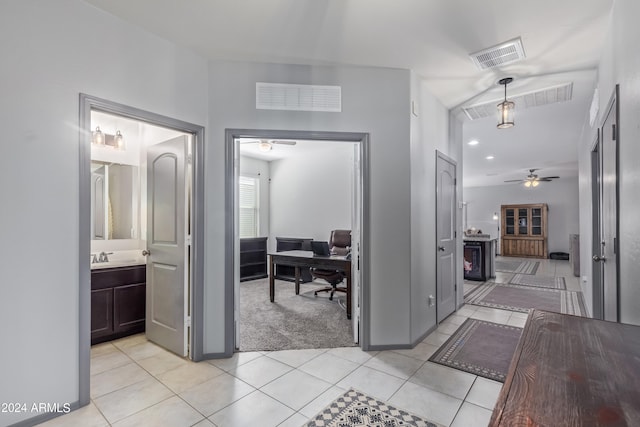 corridor featuring sink and light tile patterned floors