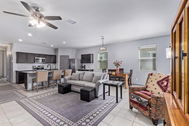 tiled living room featuring plenty of natural light, sink, and ceiling fan