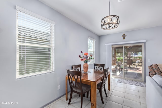 dining space featuring light tile patterned flooring and a chandelier