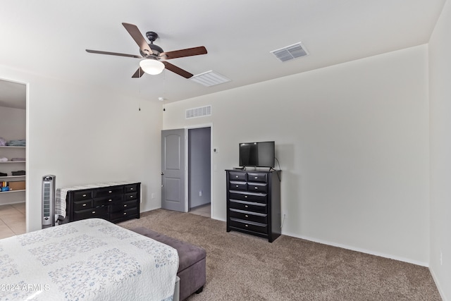 bedroom featuring ceiling fan, light colored carpet, and a spacious closet