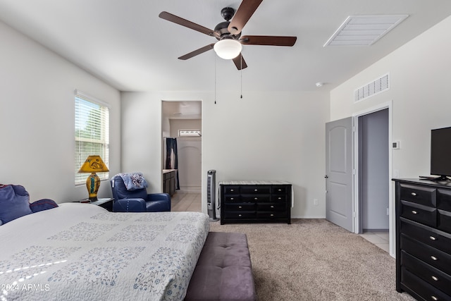 carpeted bedroom with ensuite bath and ceiling fan