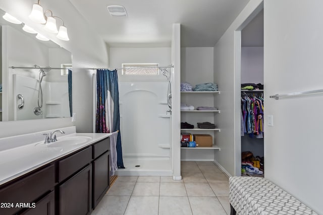 bathroom featuring walk in shower, vanity, and tile patterned flooring