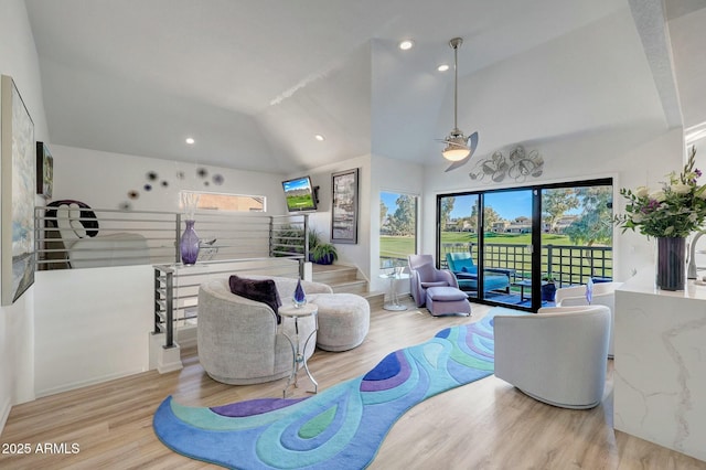 living room featuring high vaulted ceiling and light hardwood / wood-style flooring