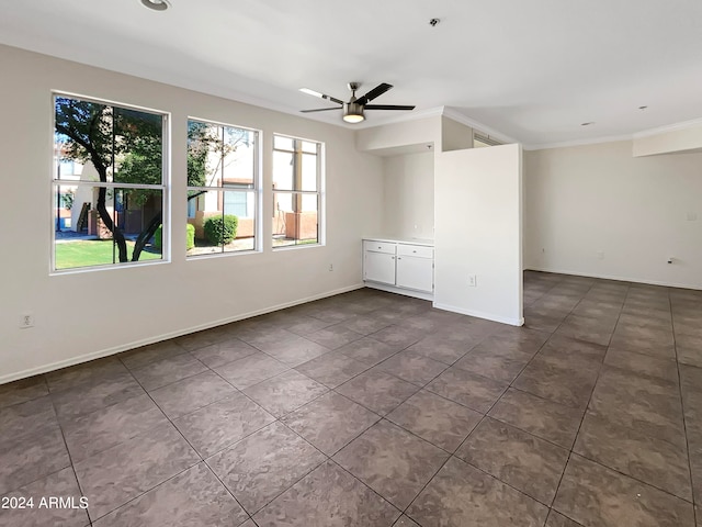 tiled spare room featuring ceiling fan and crown molding