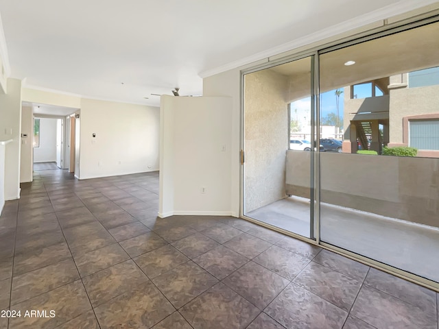 tiled spare room featuring crown molding