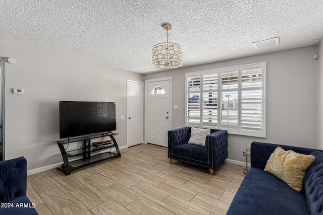 living room featuring a textured ceiling and an inviting chandelier