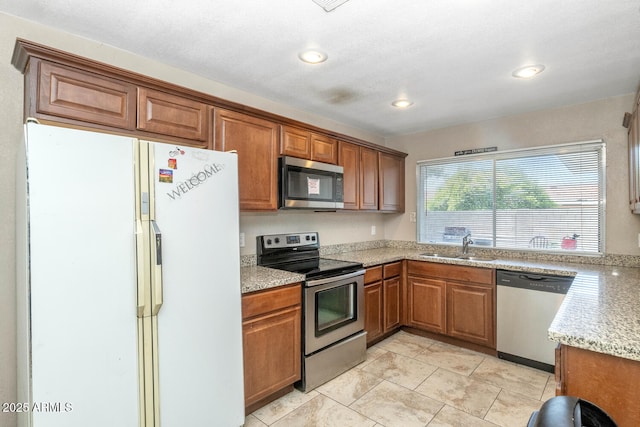 4813 W Belmont Ave, Glendale, AZ 85301 - kitchen with a sink, appliances with stainless steel finishes, brown cabinetry, and light tile patterned flooring