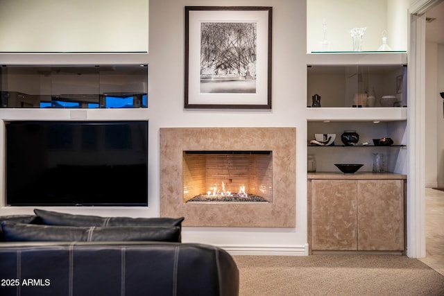 living room featuring carpet floors, built in shelves, and a high end fireplace