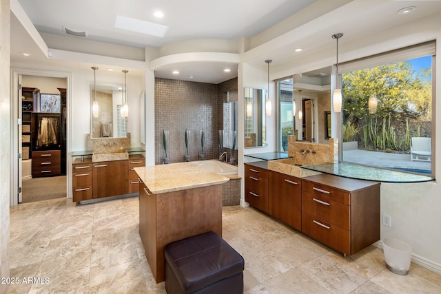 bathroom featuring vanity, a bathtub, and a skylight