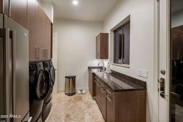 laundry area featuring cabinets, separate washer and dryer, and sink