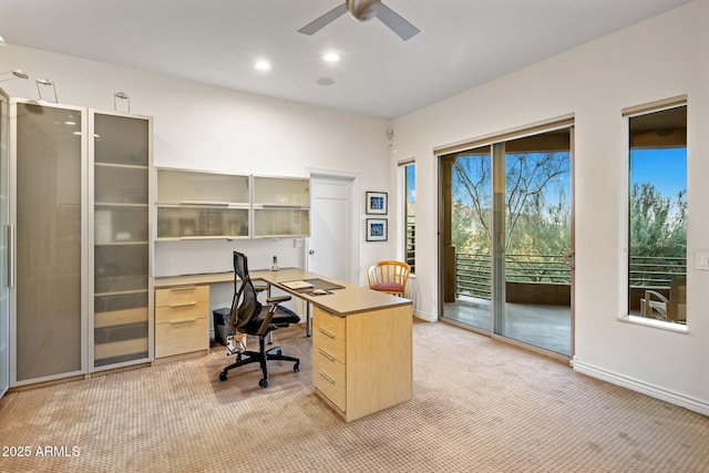 carpeted office space with ceiling fan