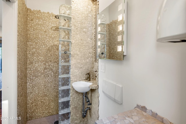 bathroom with sink and tiled shower