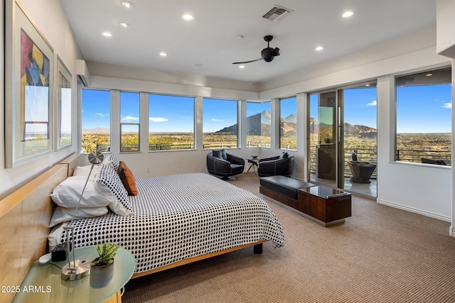 carpeted bedroom with a mountain view and access to exterior