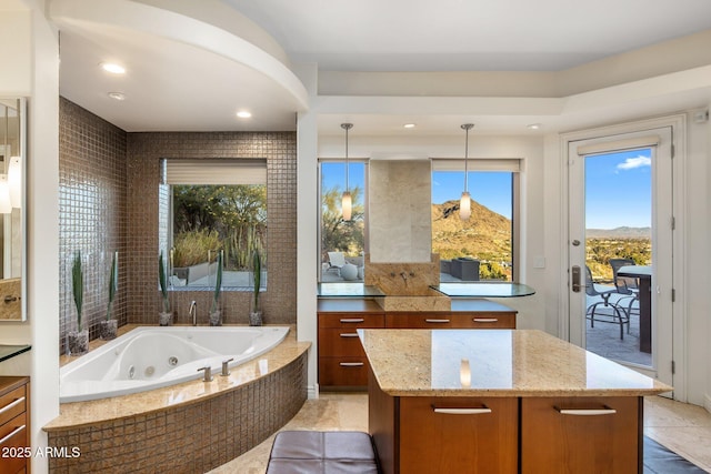 bathroom featuring vanity, tiled bath, a mountain view, and tile patterned flooring