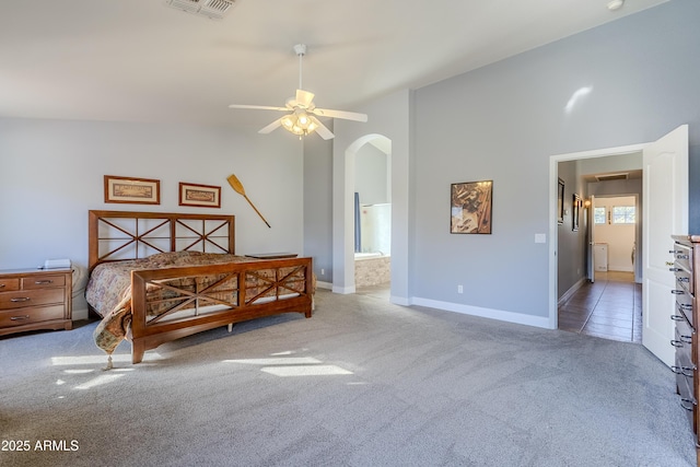 carpeted bedroom featuring connected bathroom, vaulted ceiling, and ceiling fan