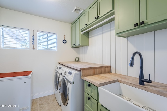 laundry room with sink, light tile patterned floors, cabinets, and washing machine and clothes dryer