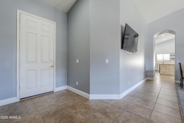 entrance foyer featuring lofted ceiling and light tile patterned floors