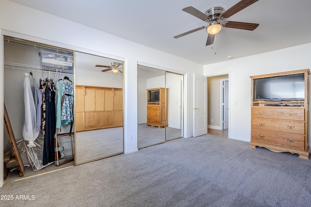 unfurnished bedroom featuring multiple closets, ceiling fan, and carpet flooring