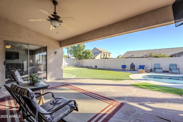 view of patio / terrace with a fenced in pool and ceiling fan