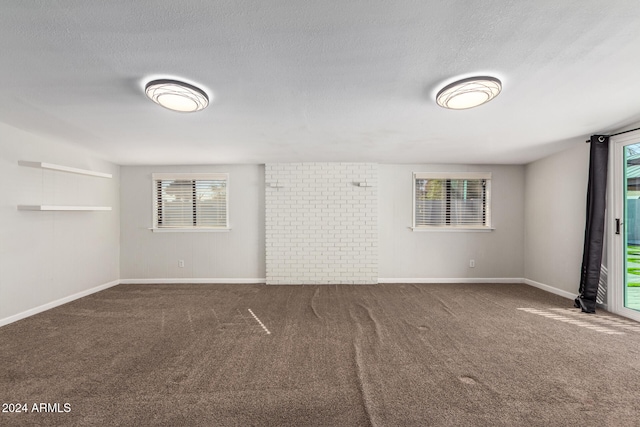 empty room with a textured ceiling and carpet floors