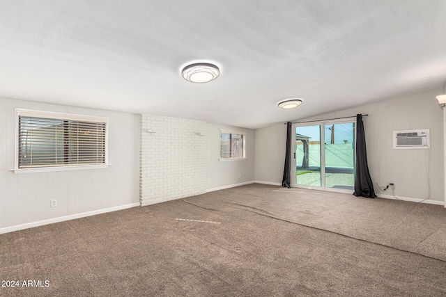 spare room with carpet floors, an AC wall unit, and vaulted ceiling