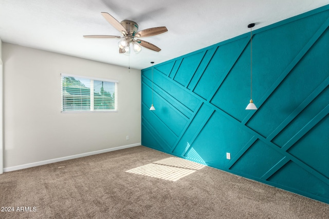 carpeted spare room featuring ceiling fan