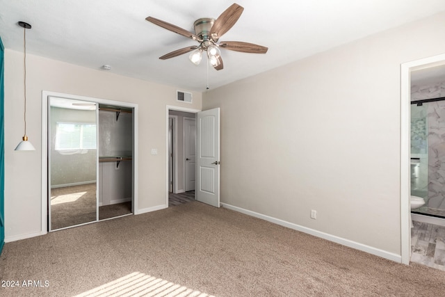 unfurnished bedroom featuring ensuite bath, ceiling fan, a closet, and carpet floors