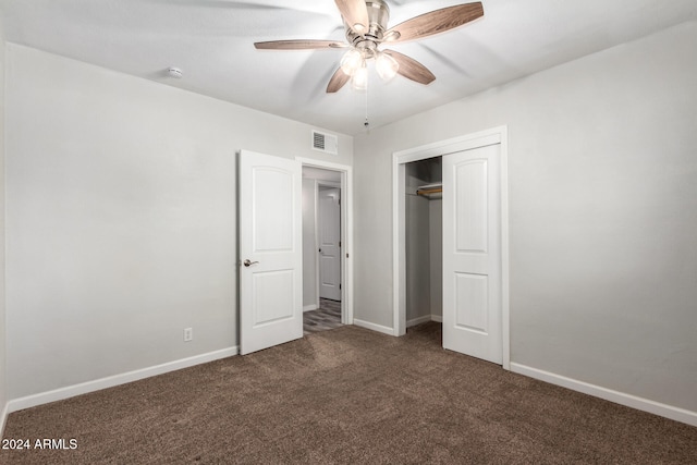 unfurnished bedroom with ceiling fan, dark carpet, and a closet