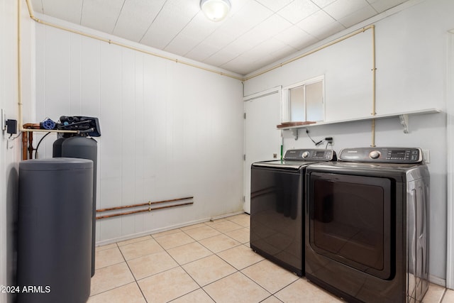 laundry room with washer and dryer, light tile patterned flooring, ornamental molding, and wooden walls