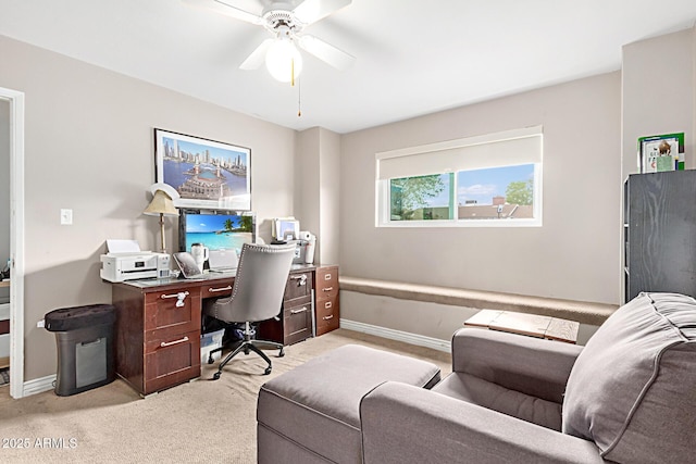 office featuring light carpet, baseboards, and ceiling fan