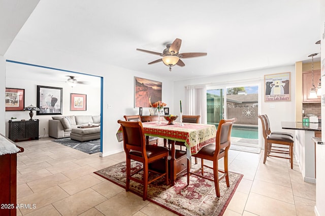 dining space with light tile patterned floors, baseboards, and a ceiling fan